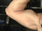 Big Muscle Woman flexing her biceps in Gym